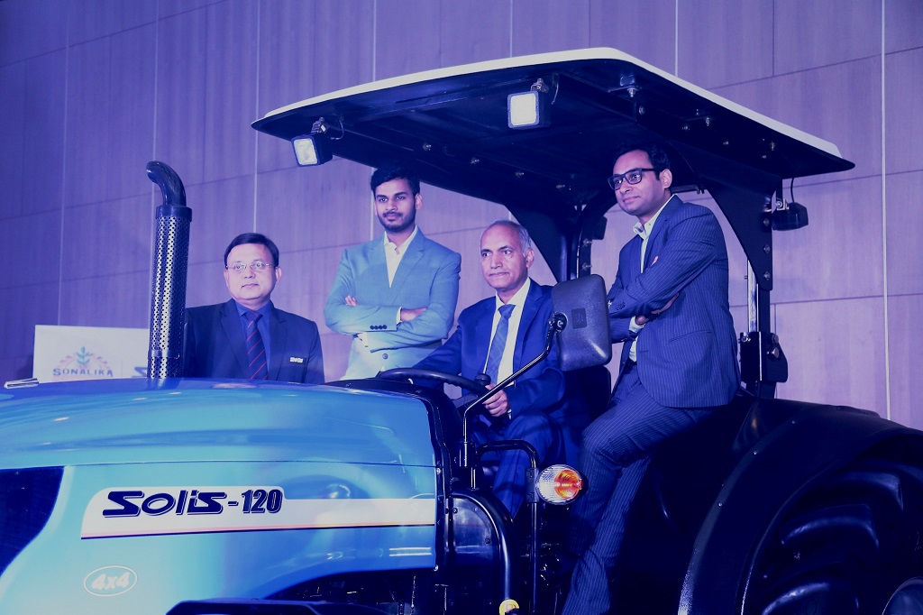 Mr. Deepak Mittal in middle sitting on 120 Hp tractor, Mr. Raman Mittal on extreme Left with Mr. Rahul Mittal on right of deepak Mittal with Gaurav Saxena on extreme right