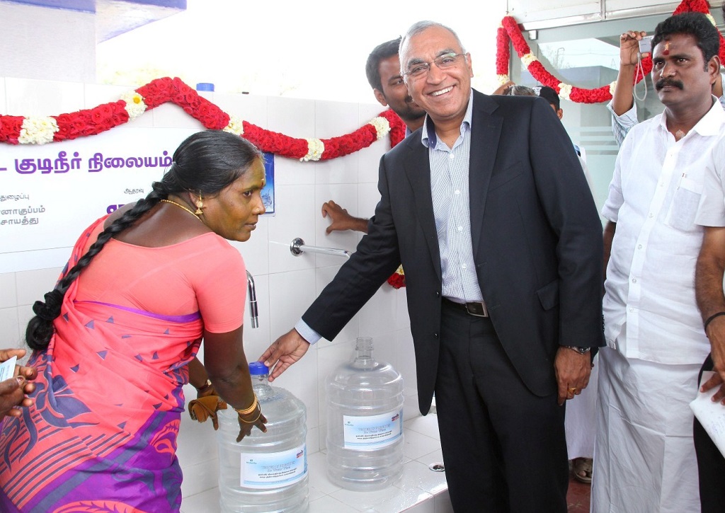 Satish Sharma, President, APMEA, Apollo Tyres Ltd (2nd from right) handing over the first jar of water to a beneficiary post the inauguration